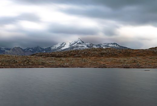 Breathtaking landscape of a snow-capped mountain under cloudy skies.