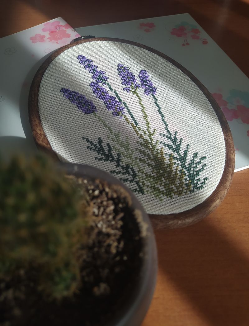 Lavender cross-stitch frame in soft purples on linen