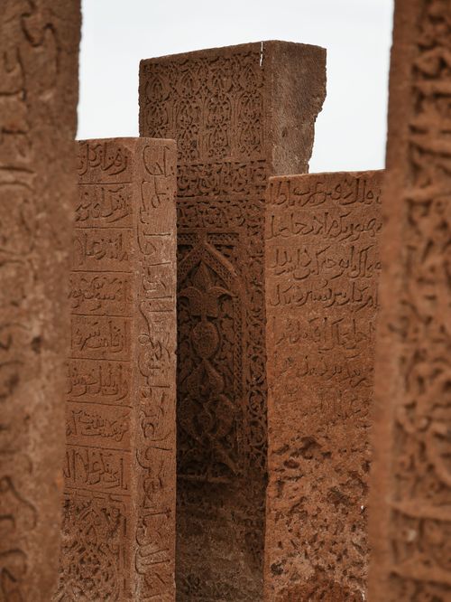 Free Intricate stone carvings with ancient scripts and patterns on historical monuments. Stock Photo
