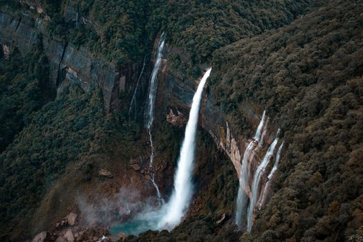 A breathtaking waterfall cascades in a lush rainforest, highlighting nature's beauty.