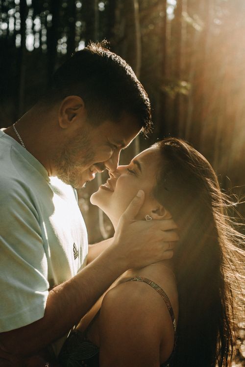 Free A loving couple shares an intimate moment in a sunlit Rio de Janeiro forest. Stock Photo