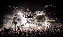 夜晚的节日场景惊心动魄，巨大的蜘蛛般舞台和热闹的人群构成了一幅生动的画面