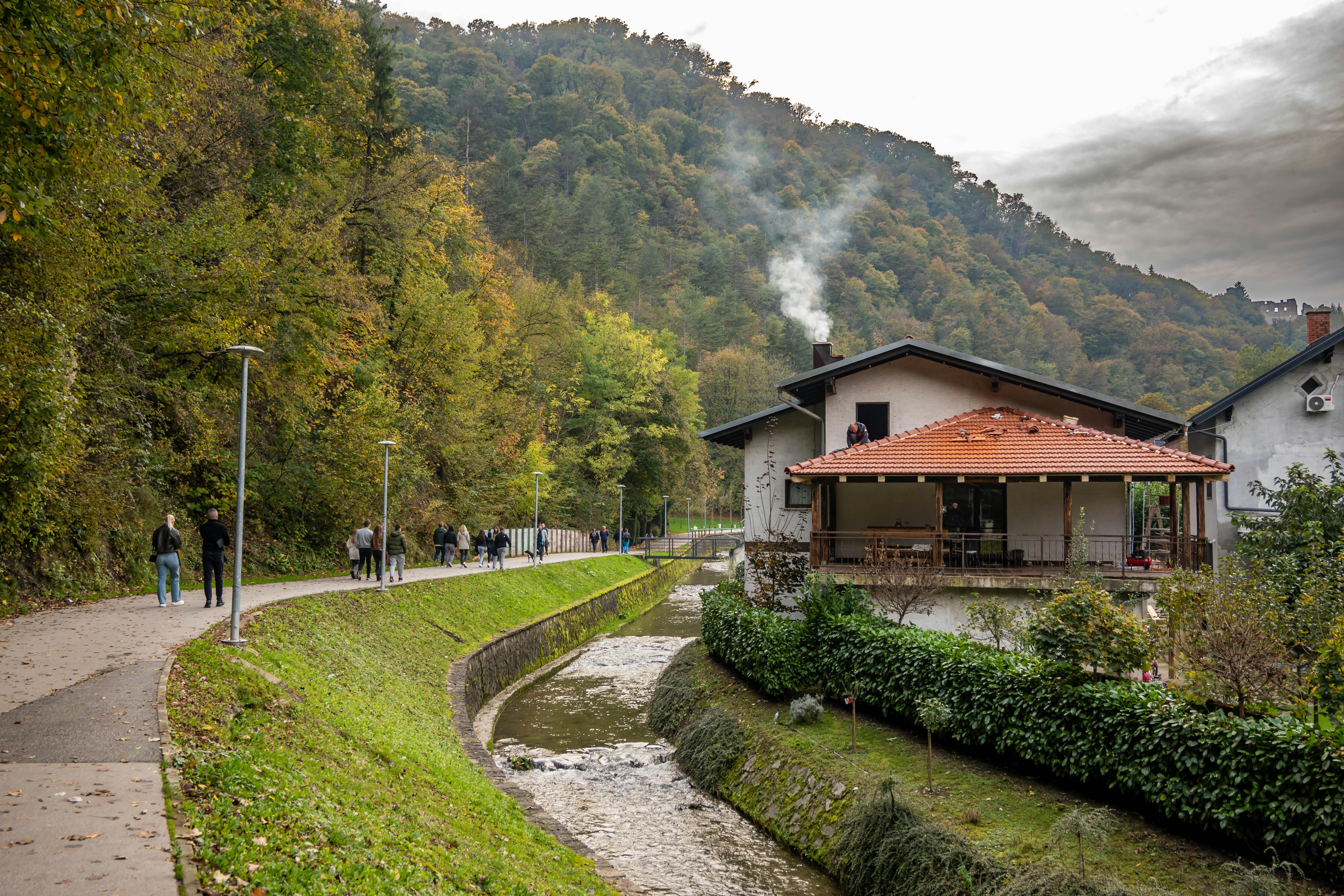 Picturesque Samobor path with autumn leaves and cozy houses along the creek.