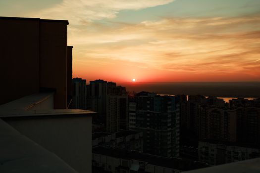 City skyline silhouette during a vibrant sunset with a dramatic sky.