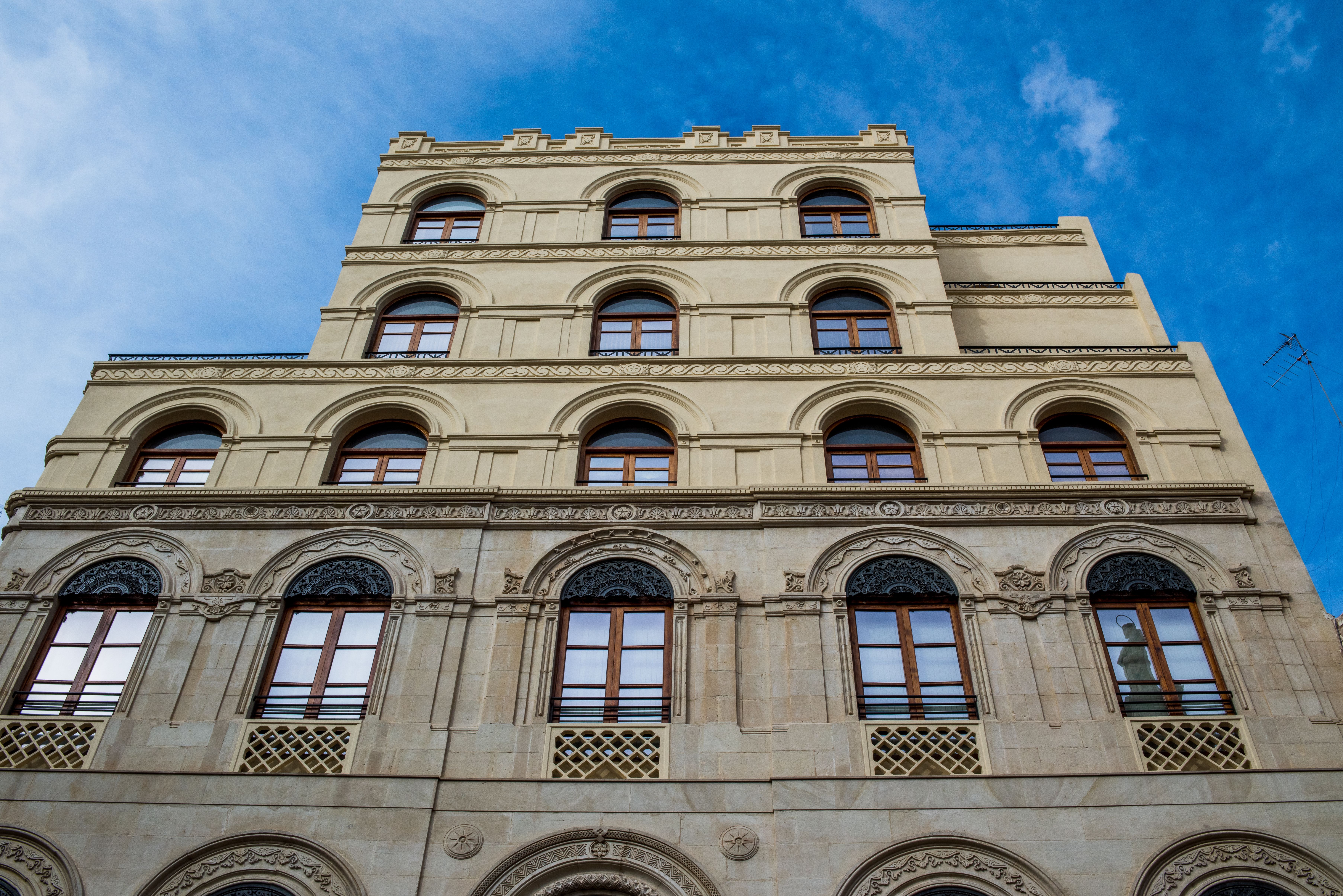 Elegant Neoclassical Building Facade Under Blue Sky · Free Stock Photo