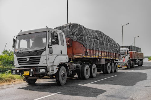 Free Heavy cargo trucks parked on a highway in Deeg, Uttar Pradesh, India, showcasing Indian logistics. Stock Photo
