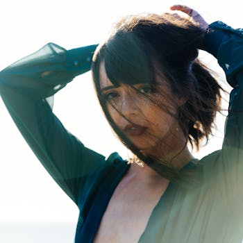 一位时尚女性身着绿色服装，秀发飘逸，在户外摆姿势的肖像