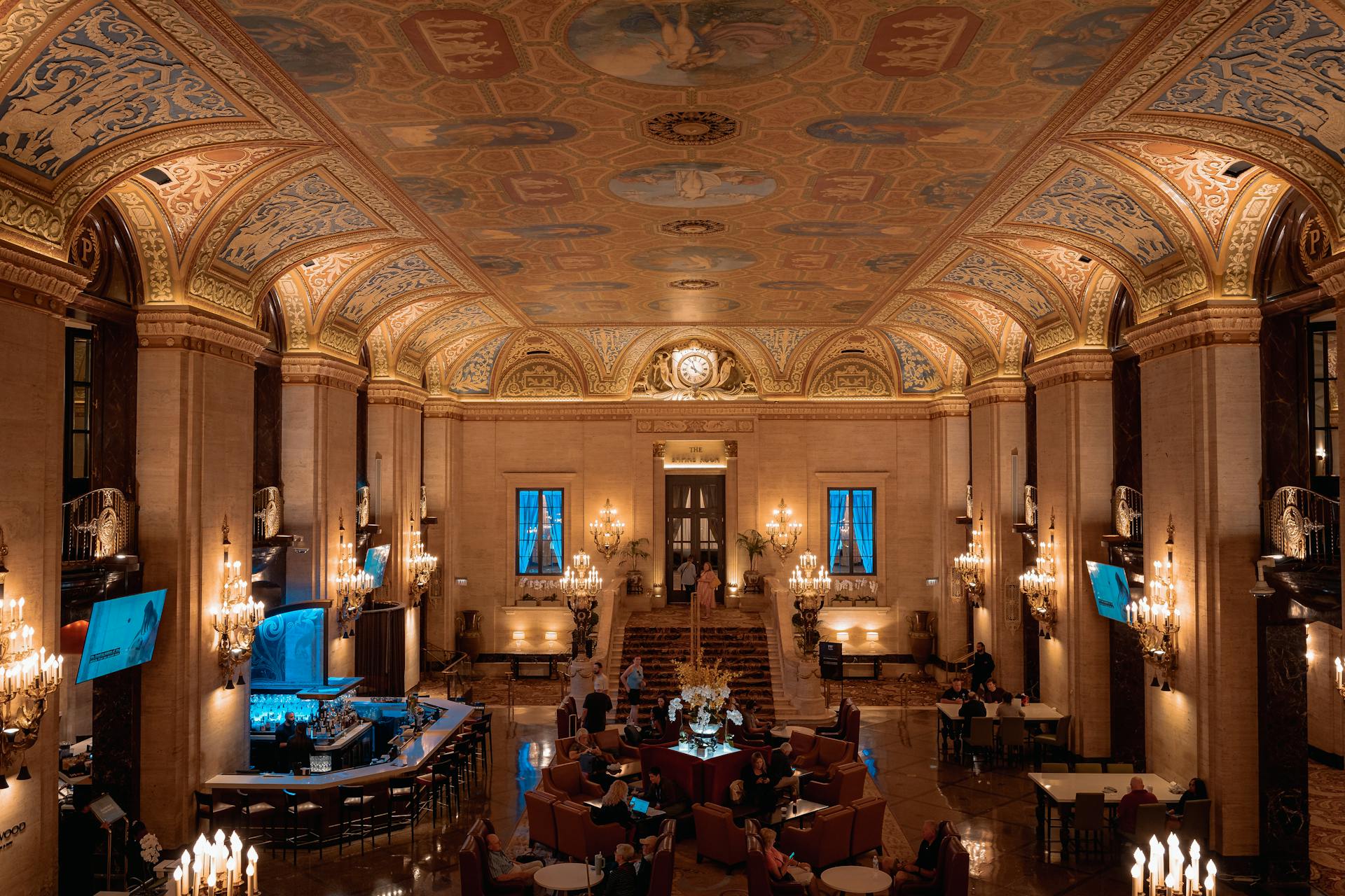 Luxurious hotel lobby with ornate ceiling and elegant chandeliers.