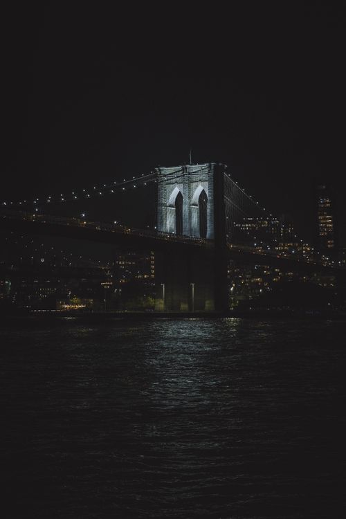 Free Captivating night view of the illuminated Brooklyn Bridge against New York City skyline. Stock Photo