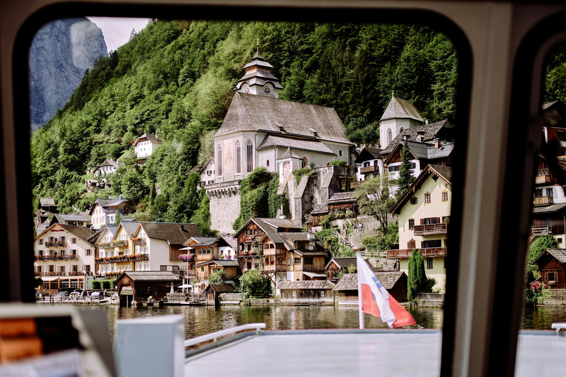 Capture of Hallstatt's charming architecture and serene lake view from a boat, reflecting Austrian beauty.