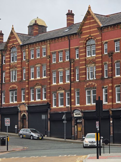 Free A classic red brick building on an empty urban street, showcasing historic architecture. Stock Photo