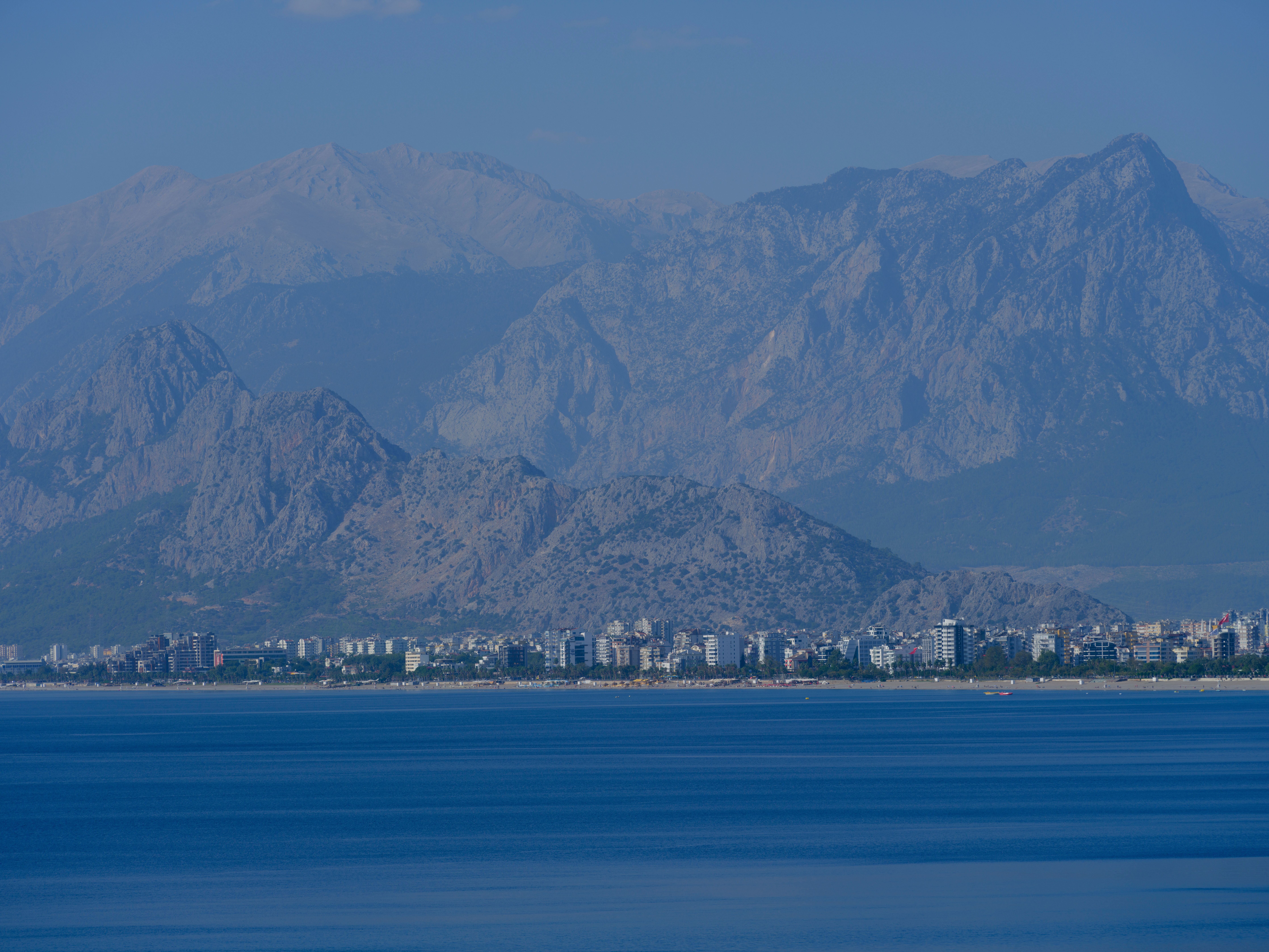 Peaceful view of Antalya city with impressive mountains and serene blue sea.