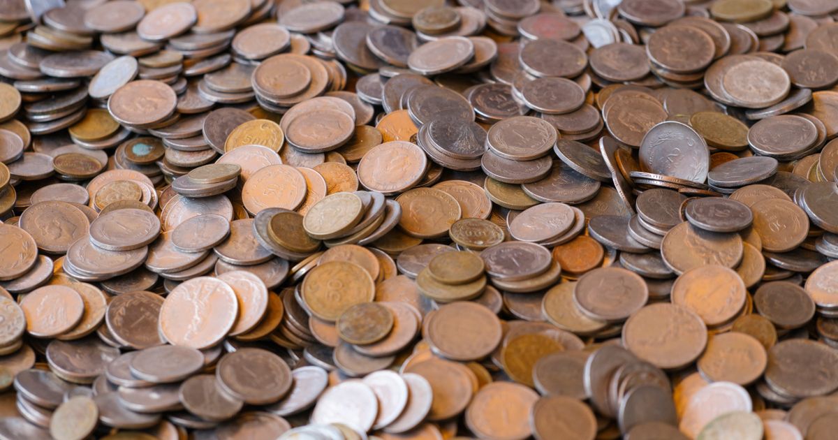 Stacks of gold coins beside a calculator representing income