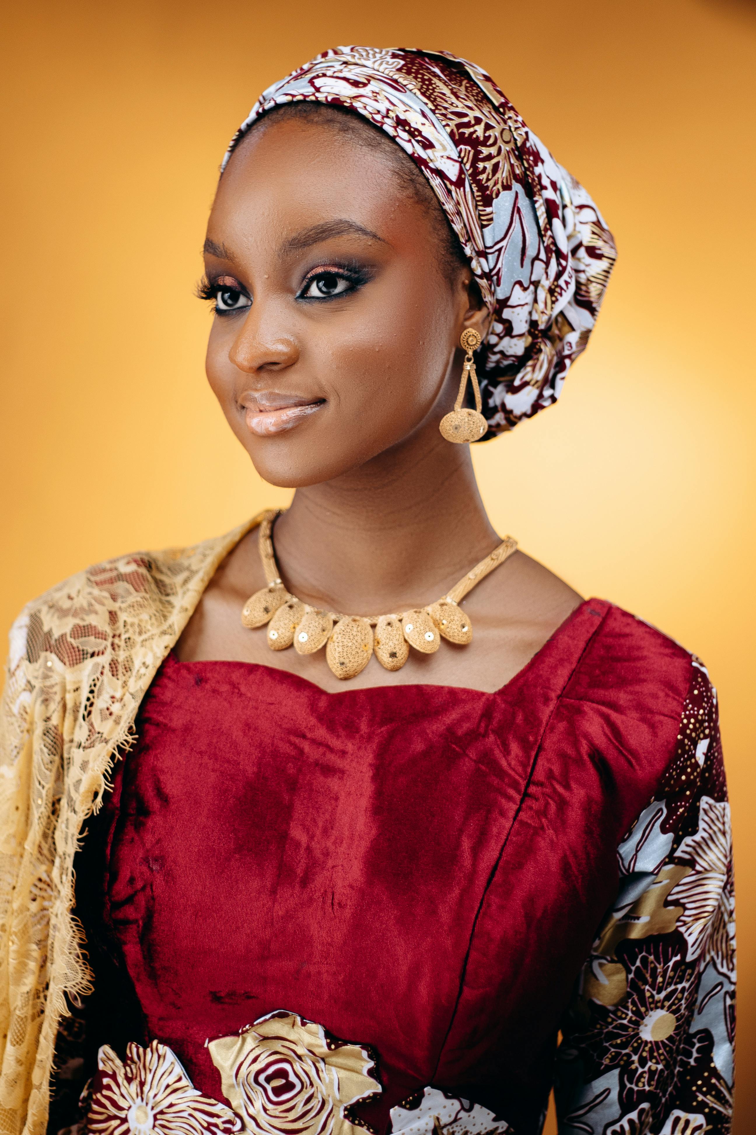 Beautiful portrait of a woman in traditional Nigerian attire featuring vibrant patterns and jewelry.