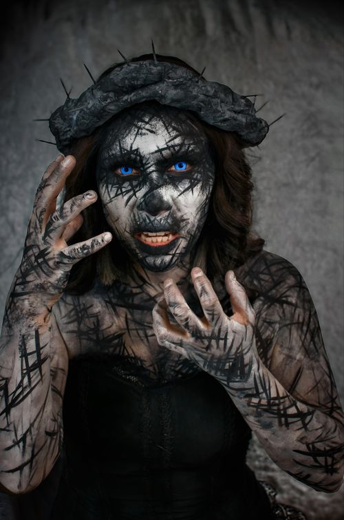 Free A woman with eerie makeup resembling a supernatural creature, perfect for Halloween themes. Stock Photo