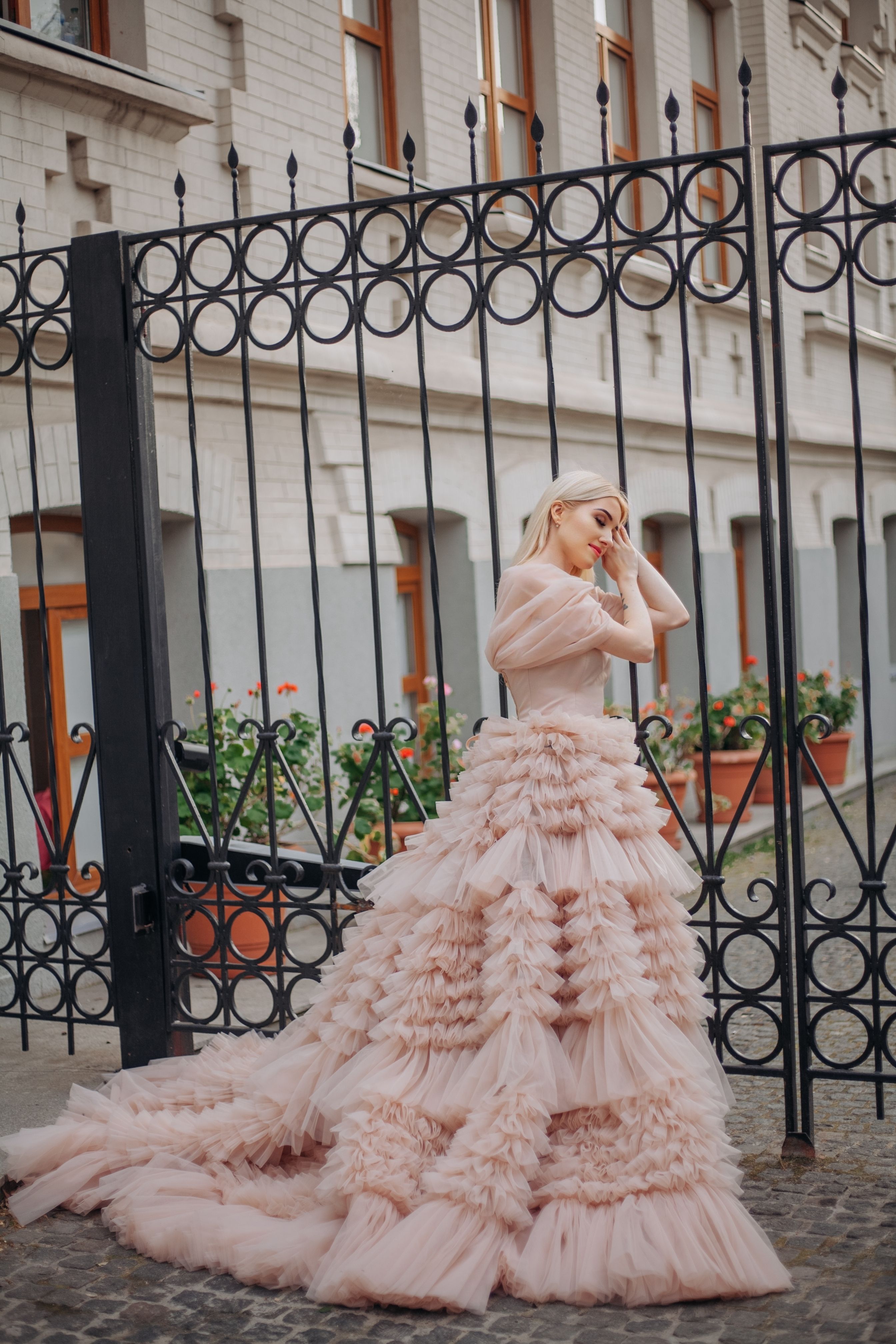 Elegant Woman in Pink Gown by Ornate Gate
