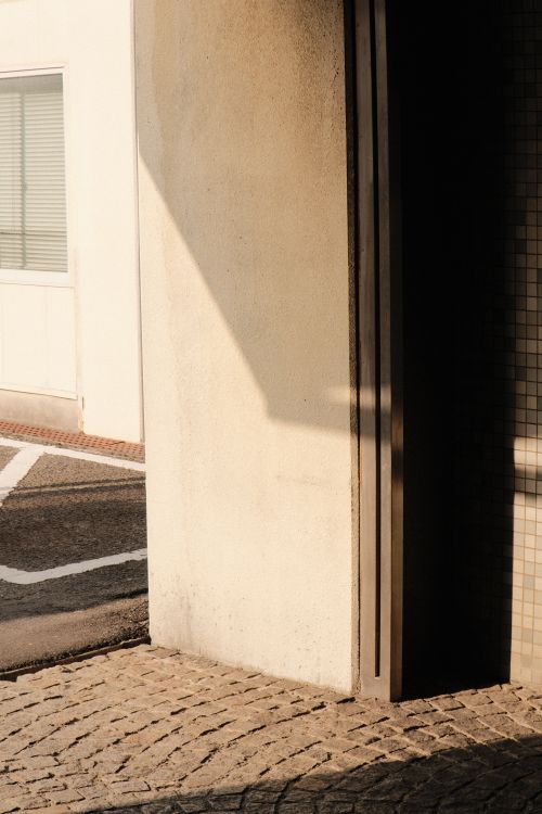 Free Intriguing urban scene with strong shadows and warm lighting on building exterior. Stock Photo