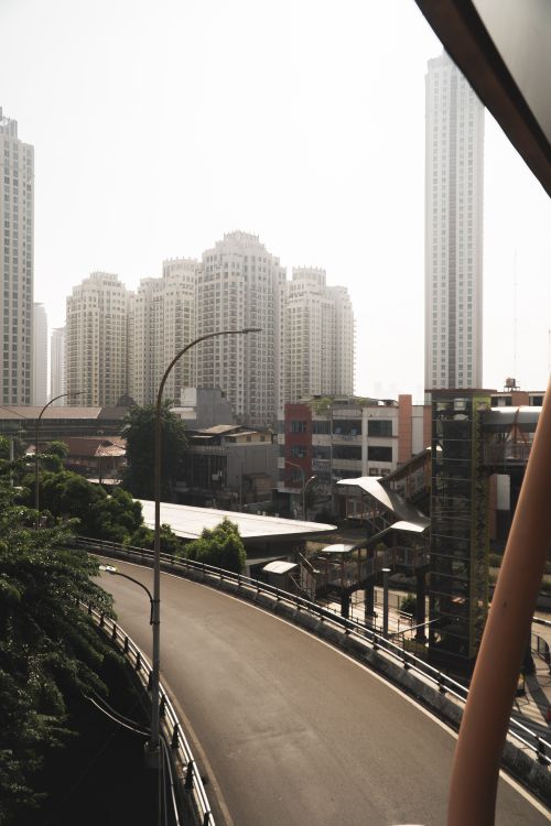 Free Cityscape featuring towering skyscrapers and a winding road. Modern urban life captured. Stock Photo