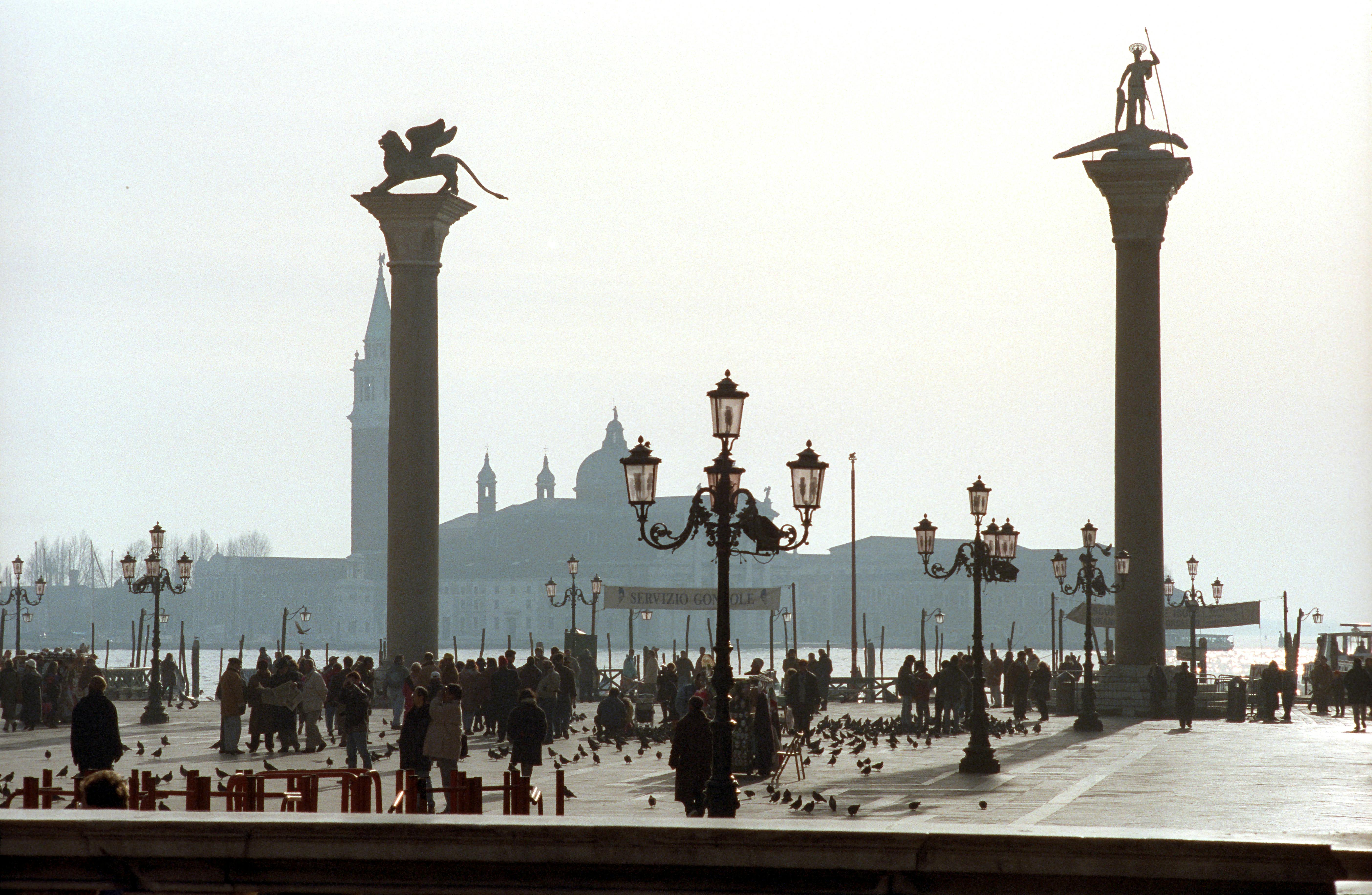 A bustling Venetian piazza with the San Giorgio Maggiore island in the background.