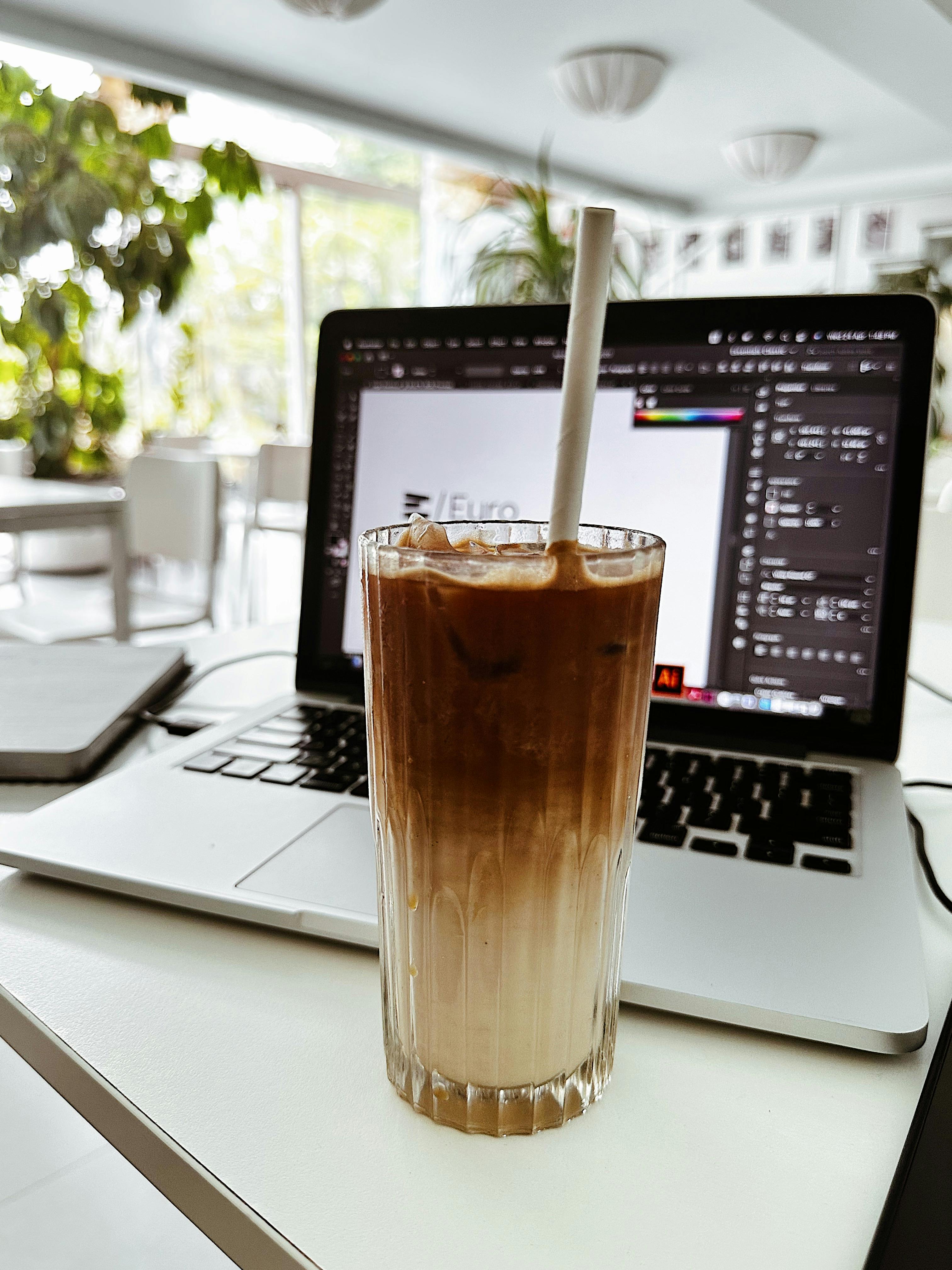 Bright home office with a laptop showing a simple graphic design template