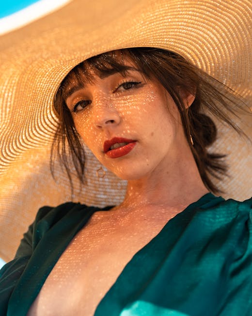 A fashionable woman with red lips and freckles wearing a sun hat, captured outdoors in San Francisco.