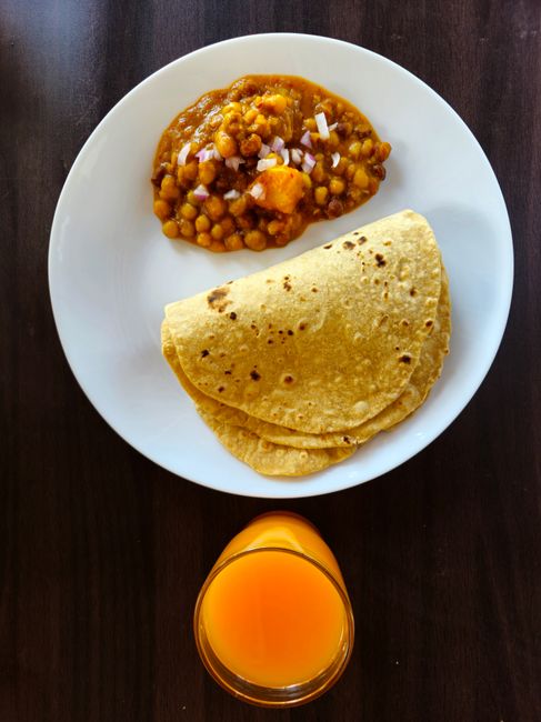 A hearty North Indian chickpea curry simmered in a spiced onion-tomato base, tangy from amchur and dried pomegranate seed.