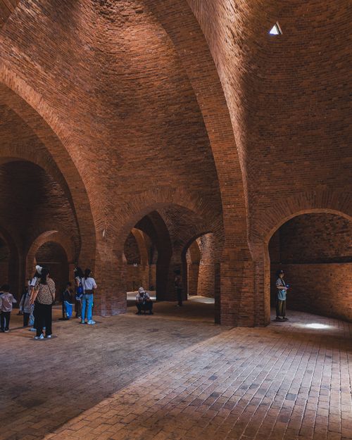 Free Group of tourists inside an ancient brick building with vaulted ceilings. Stock Photo