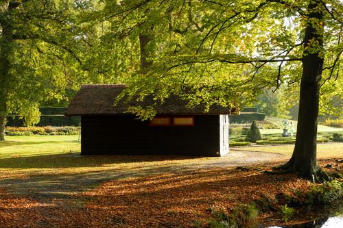 Free A serene rustic cabin nestled among fall foliage in a tranquil forest setting. Stock Photo