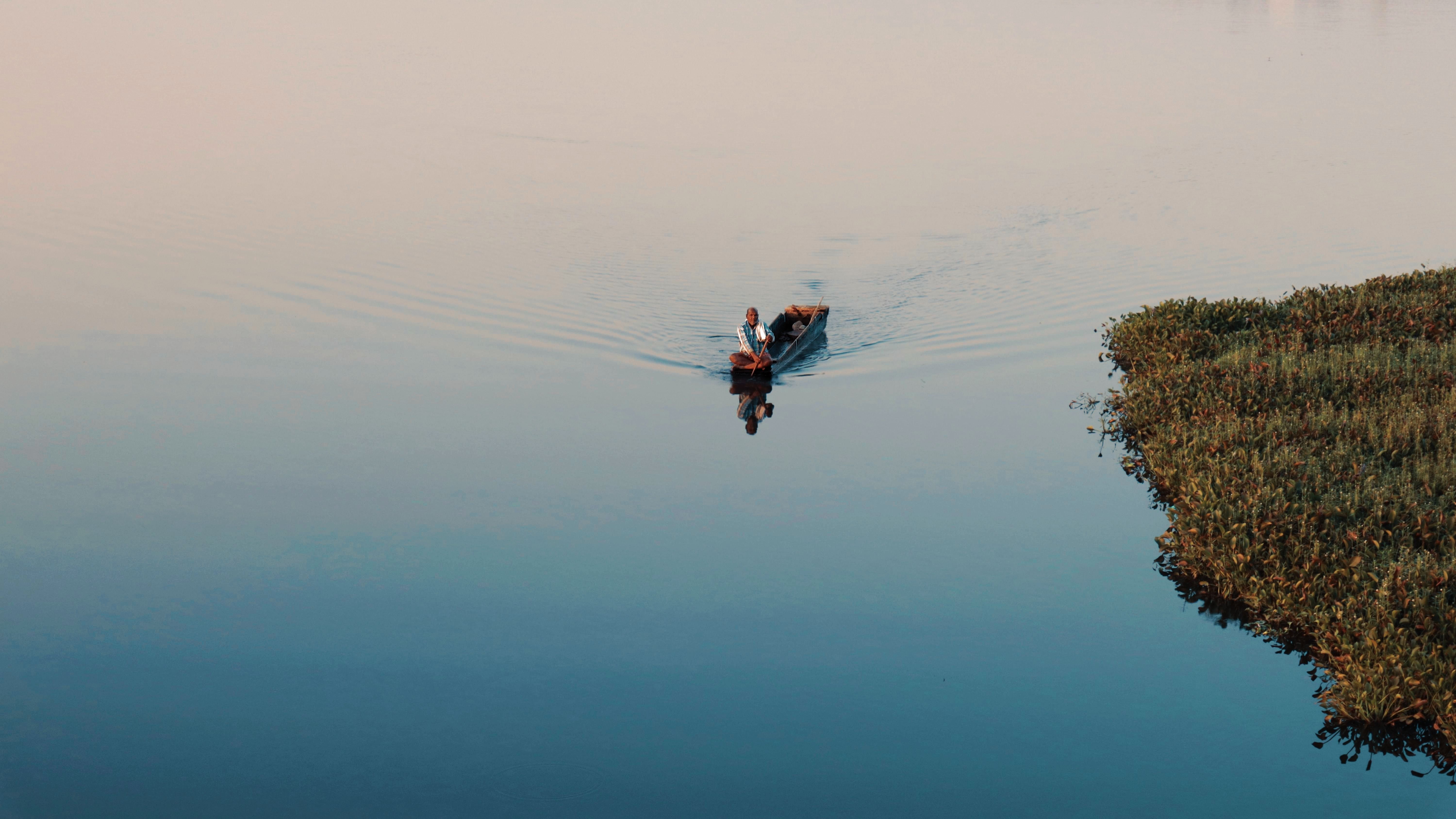 Peaceful Boat Ride on Calm Water Surface · Free Stock Photo