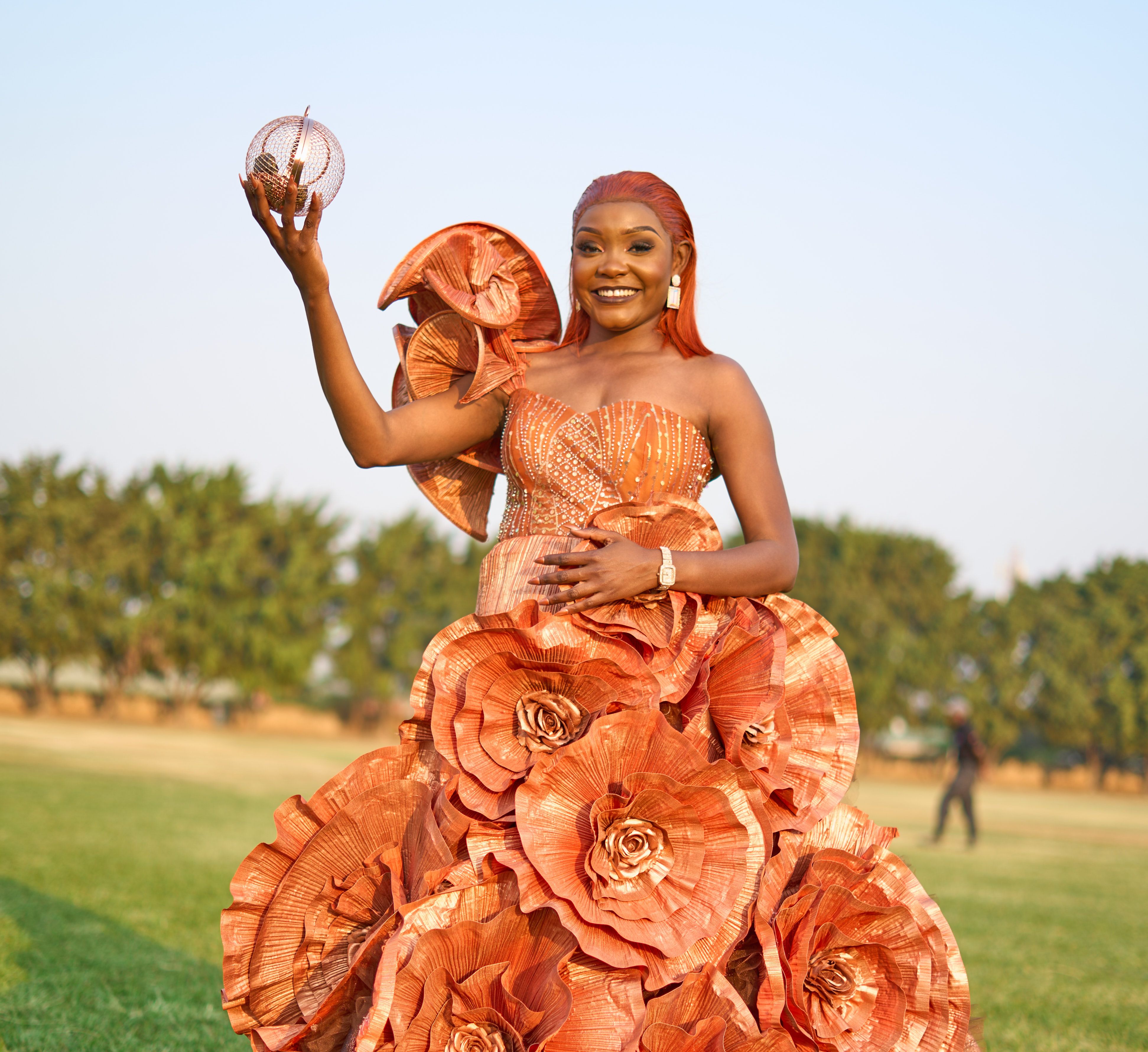 Elegant woman in a unique floral gown posing confidently outdoors in Lusaka.