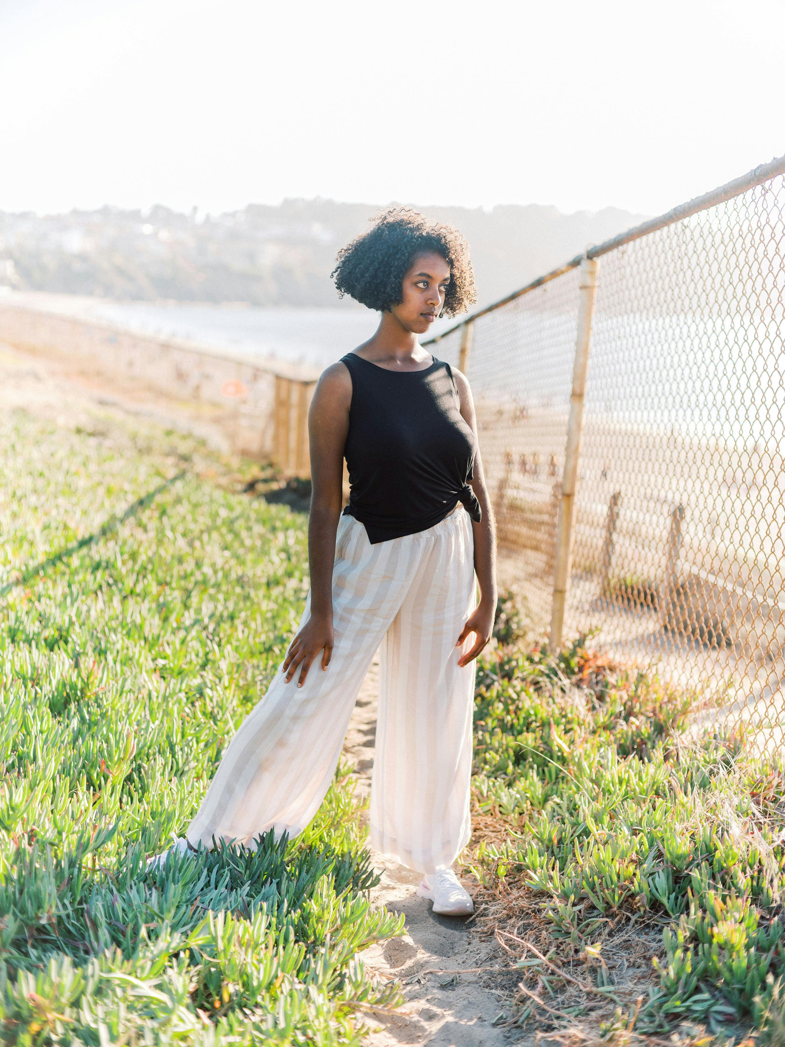 Woman in Green Sleeveless Dress Leaning on Grey Link Fence · Free Stock ...