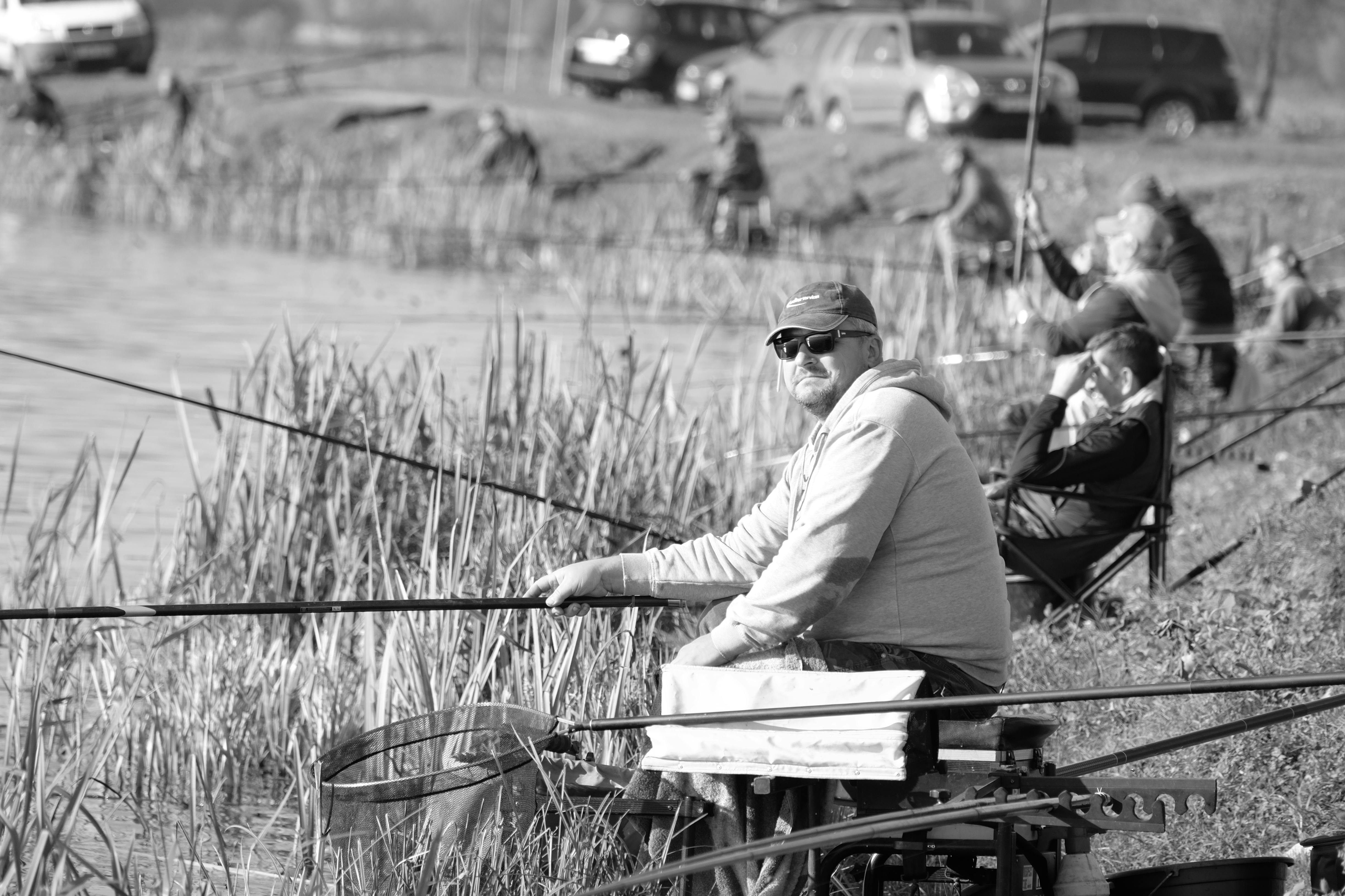Fishermen enjoying a relaxing day by the lake, showcasing leisure and outdoor activity.
