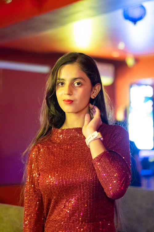 Free Portrait of a stylish woman in a dazzling red dress at a club in Varanasi, India. Stock Photo
