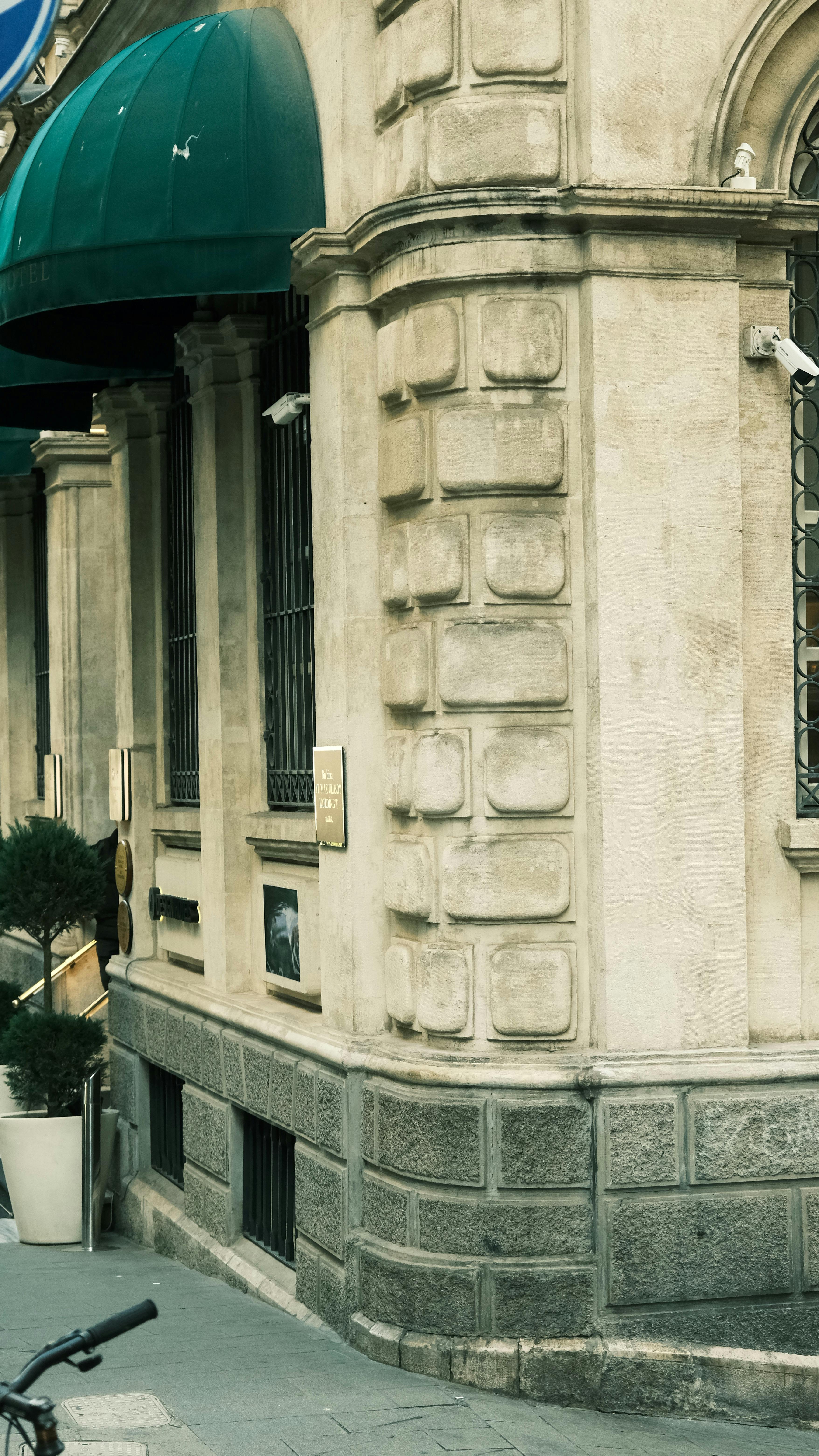 Free Elegant corner of a historic building with green awnings and ornamental architecture. Stock Photo