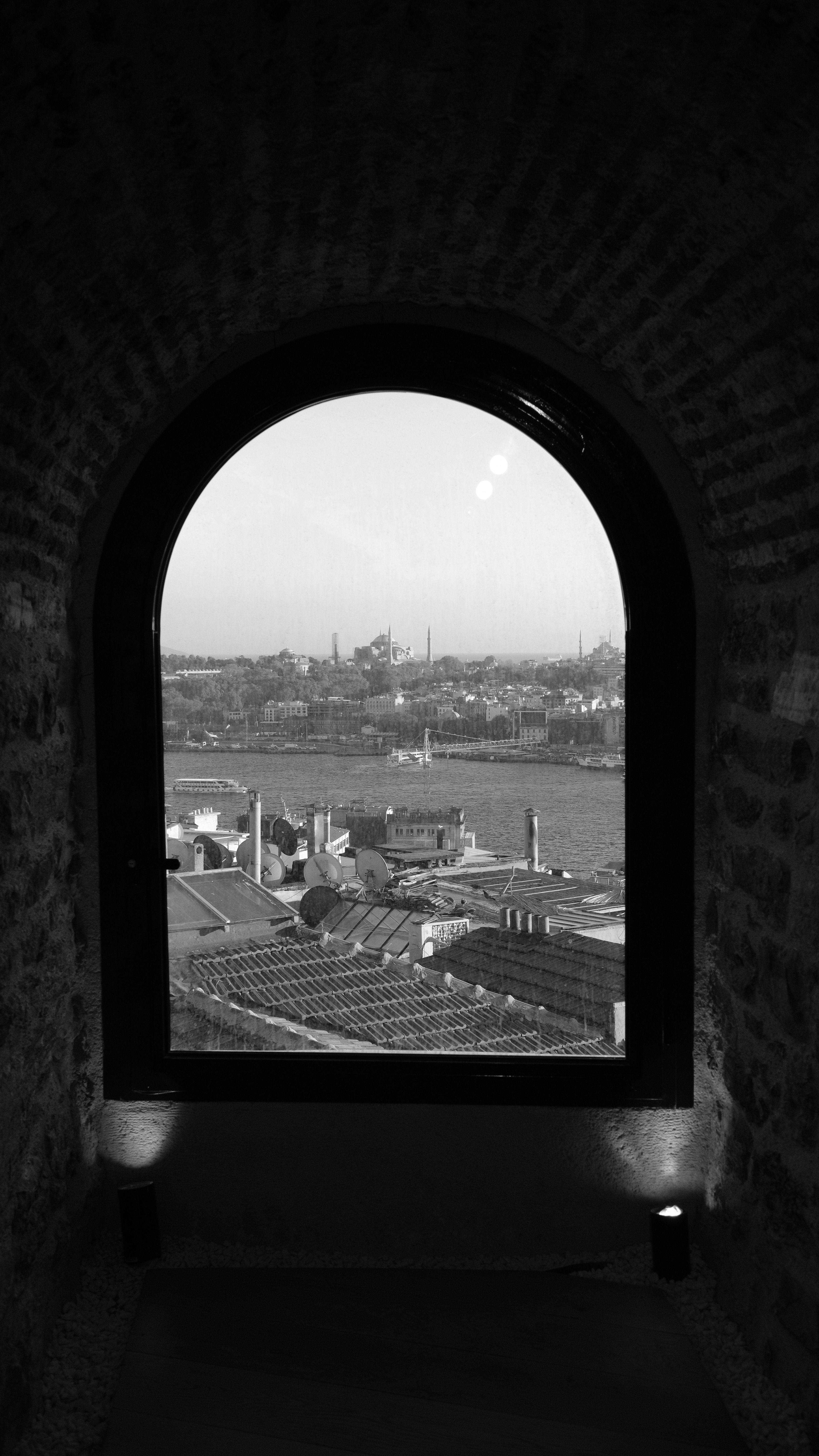 Scenic cityscape of Istanbul viewed through an arch window, in monochrome.