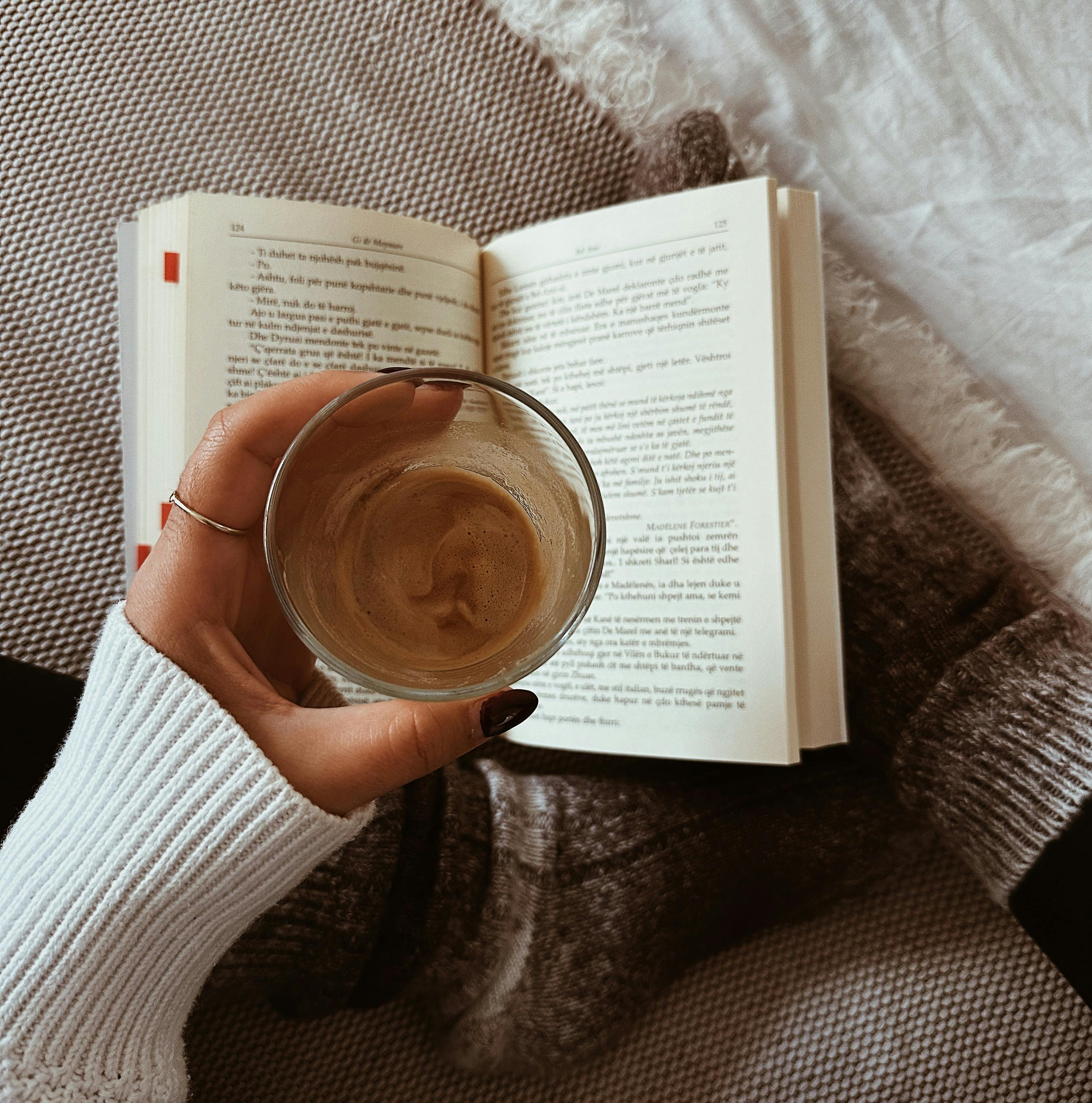 A person enjoys reading on a cozy day with coffee, wearing comfy socks indoors.
