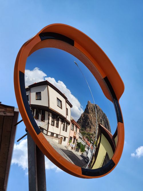 Free Circular mirror reflecting Afyonkarahisar Castle and surrounding architecture in Türkiye. Stock Photo