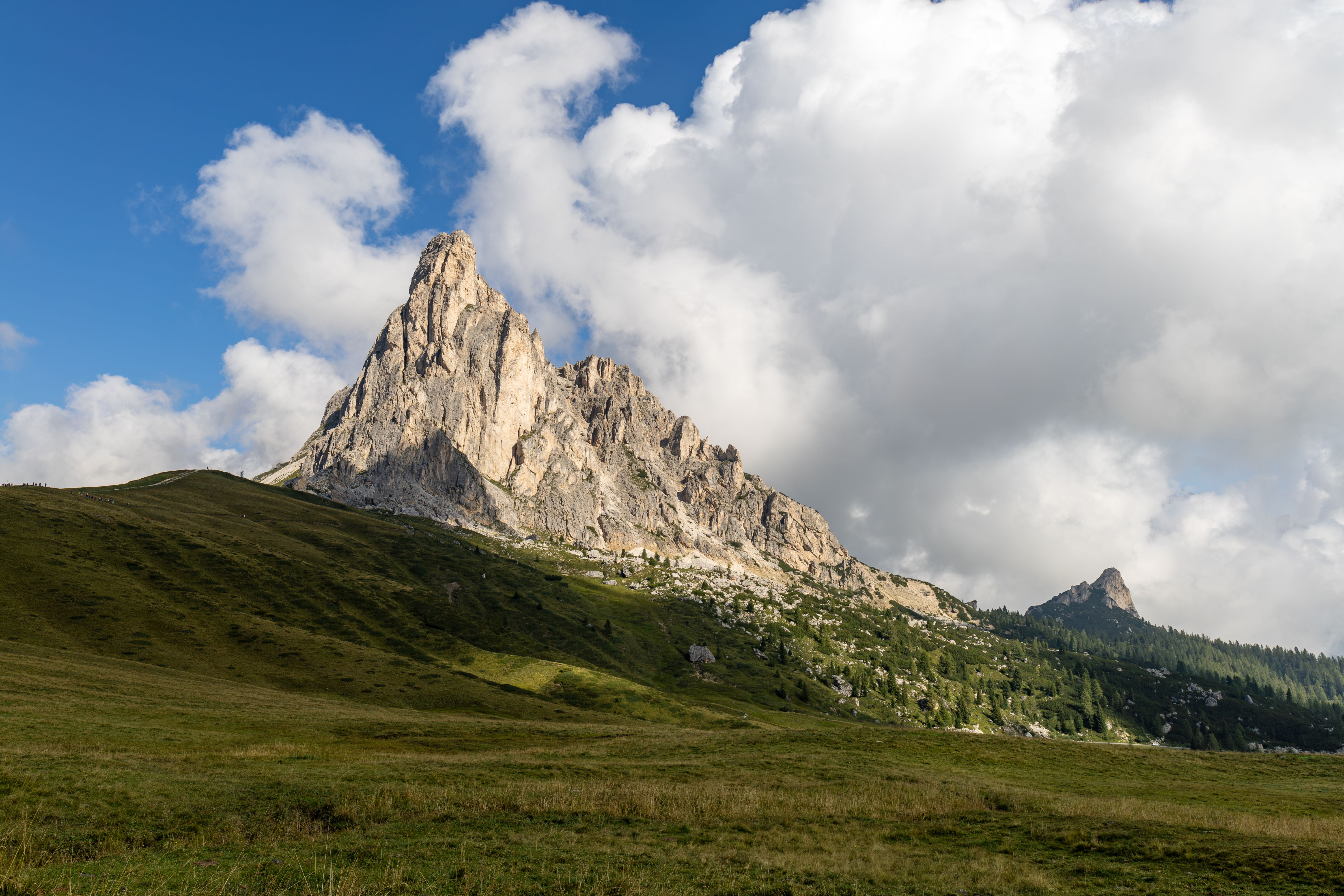 Bezpłatne Zapierający dech w piersiach widok na pasmo górskie Dolomitów we Włoszech, z bujną, zieloną trawą i czystym, błękitnym niebem. Zdjęcie z galerii