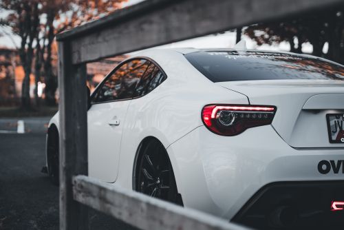 Free A stylish white sports car parked outdoors on an autumn day, showcasing its modern design. Stock Photo