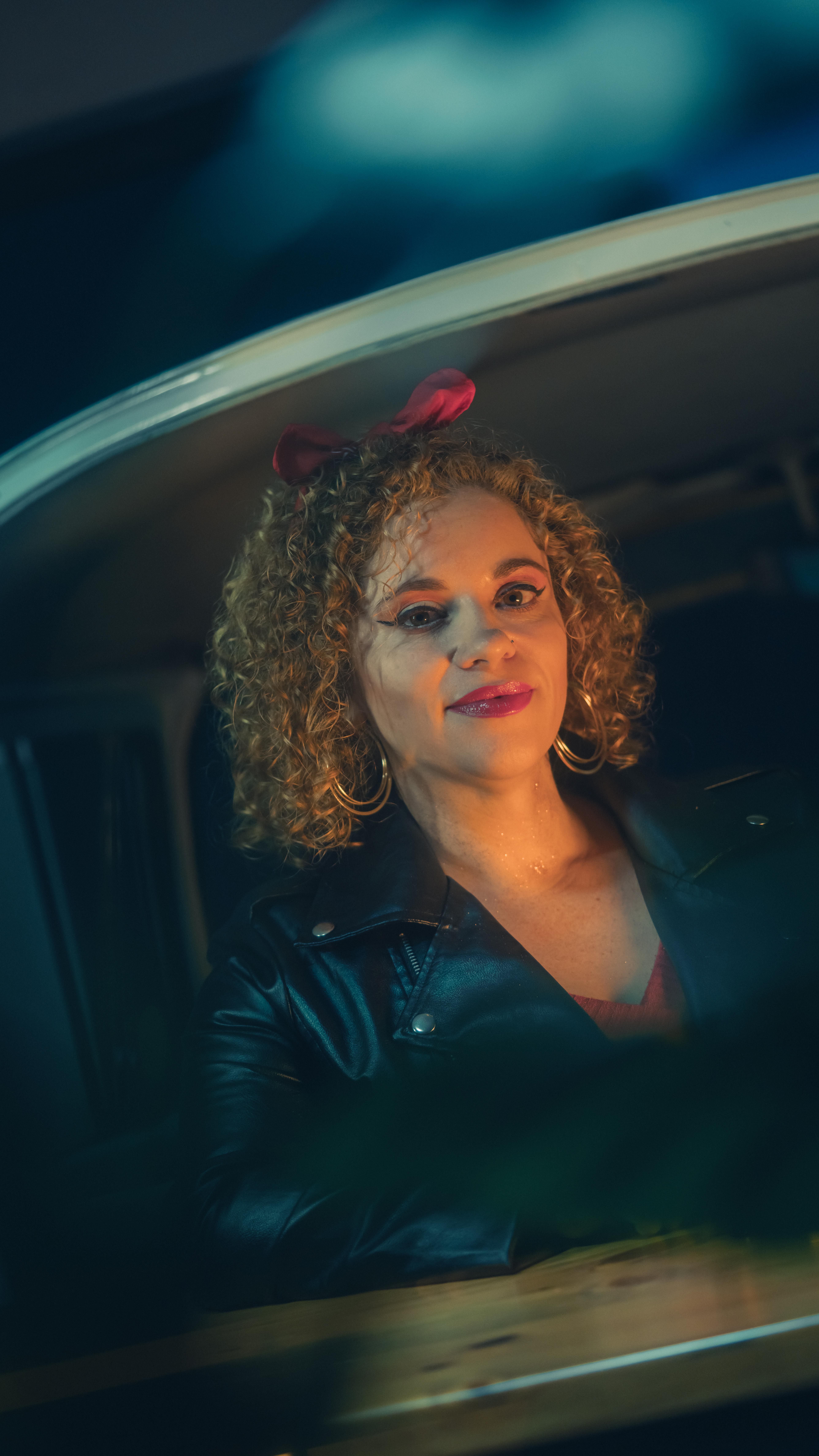Portrait of a woman with curly hair and leather jacket, vintage style.