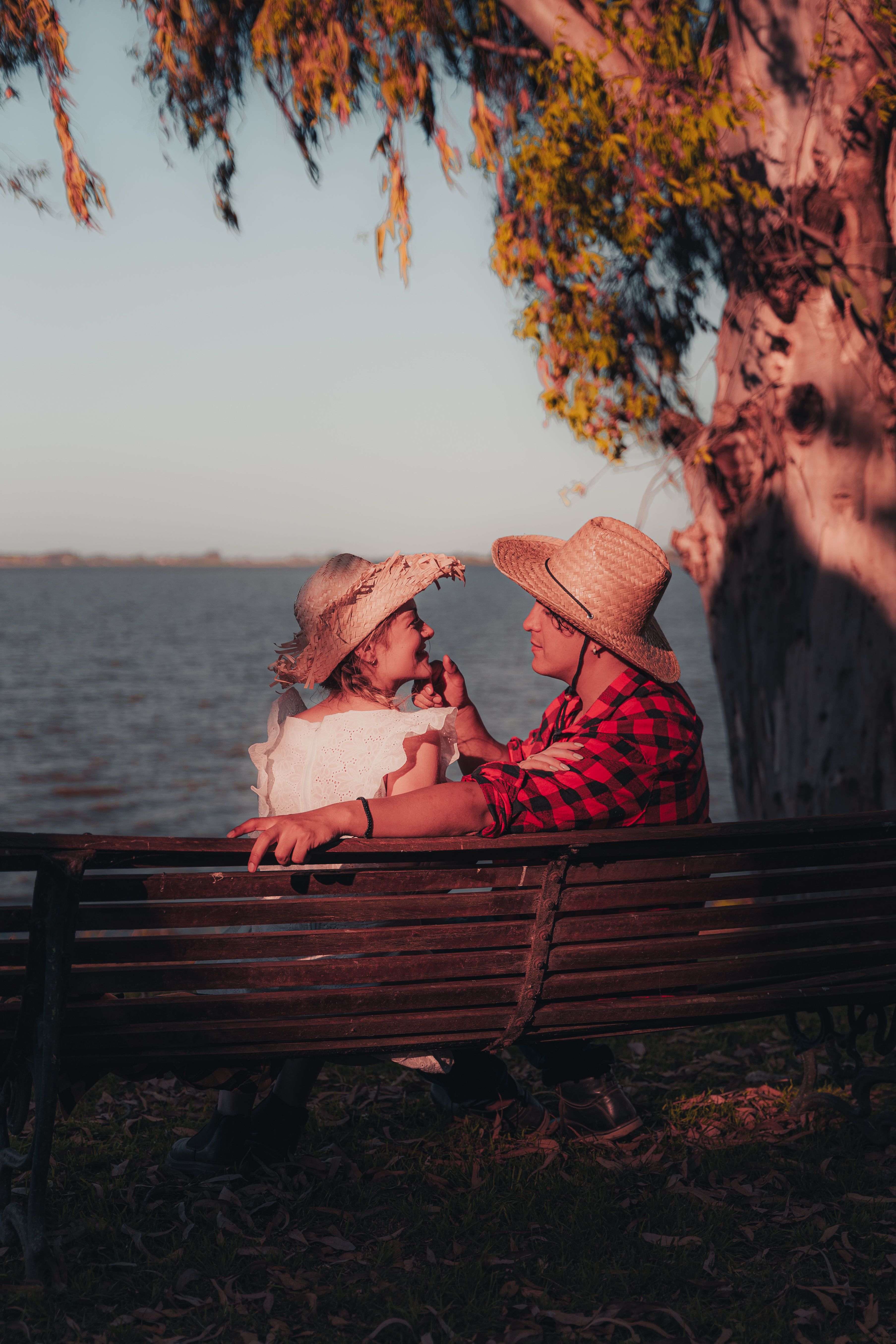 Outdoor Couple Relaxing by Lakeside in Evening Light · Free Stock Photo