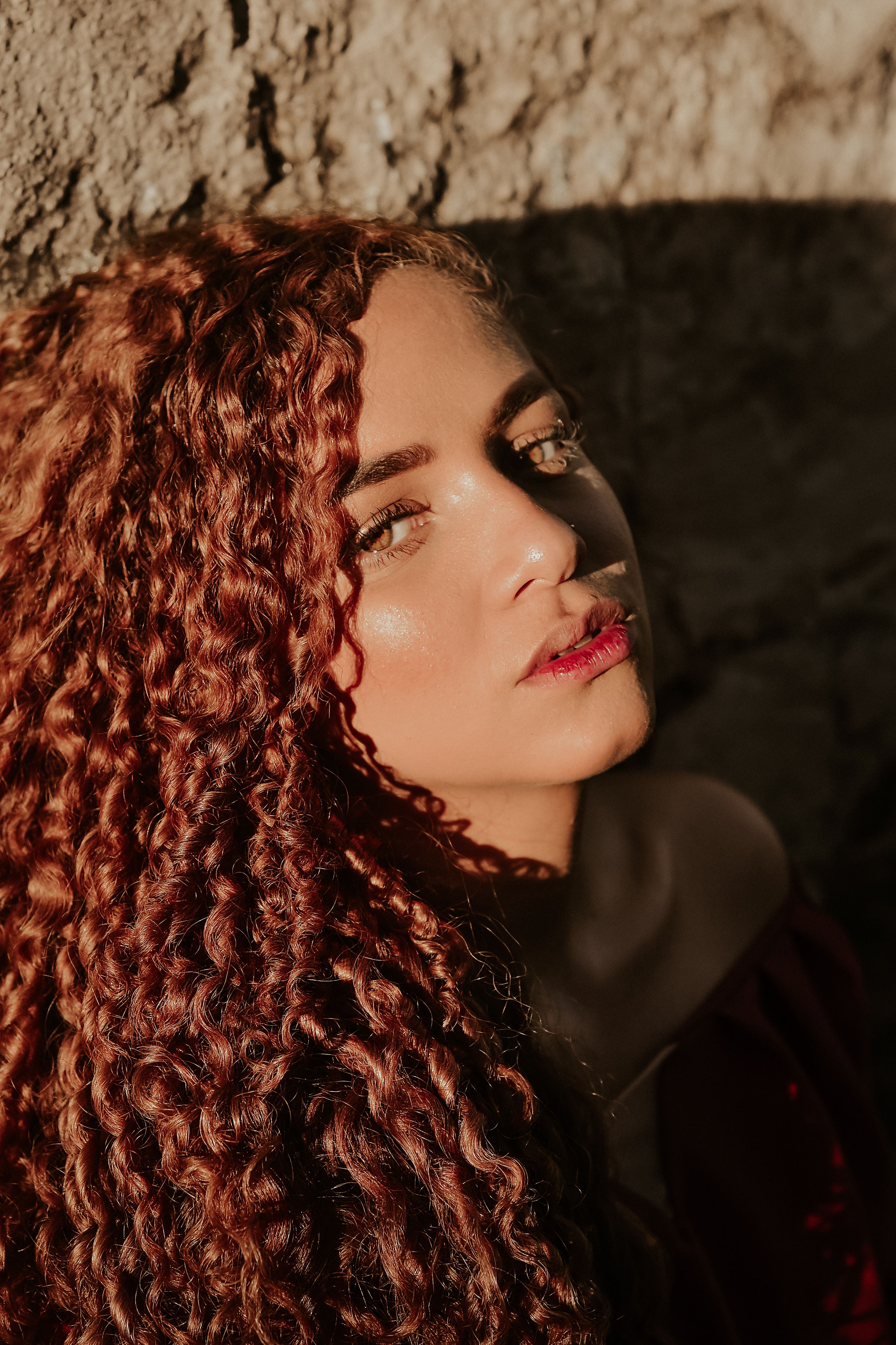 Sunlit Portrait of Woman with Curly Hair · Free Stock Photo