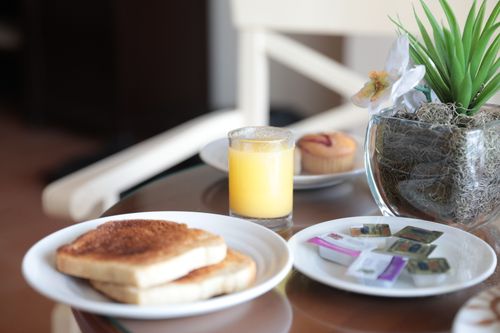 Free Inviting breakfast scene with toast, orange juice, and a plant in Montego Bay. Stock Photo