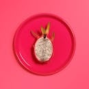 一片火龙果放在亮粉色盘子上，展现出热带新鲜感