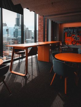 Stylish office lounge featuring city skyline view through large windows.