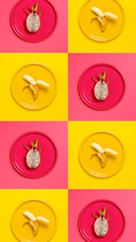 以香蕉和火龙果在彩色盘子上创造出充满活力的现代图案，展现了美食的艺术魅力