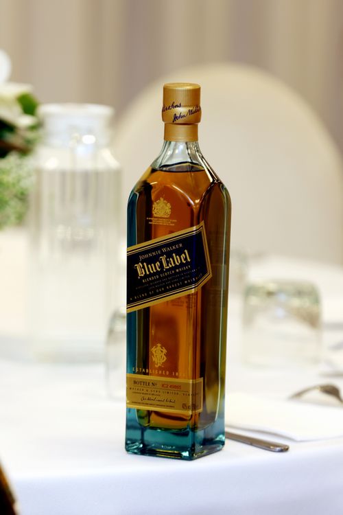 Free A sophisticated whiskey bottle elegantly displayed on a table setting. Stock Photo