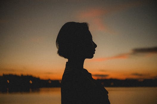 日落时分，宁静的湖边，一位女子的艺术轮廓展现出平静与安宁