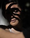 特写镜头聚焦于阴影中的女性脸庞，凸显其美丽与神秘