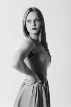 Stylish black and white portrait of a woman in a strapless dress looking confidently to the side.